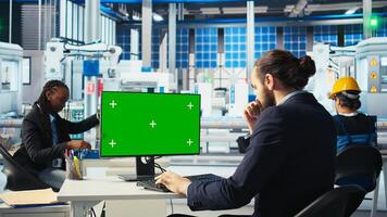 Photovoltaics factory worker analyzing data on green screen PC, reviewing system metrics. Smart manufacturing plant employee troubleshooting technical issues using chroma key computer, camera A photo