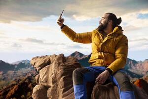 Adventure seeker capturing breathtaking scenic view at top of mountain, gazes at distant mountain range and embraces beauty of wilderness. Joy of discovering wonders. photo