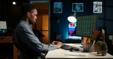 Financial advisor examines cryptocurrency market from loft workstation, looks at online global exchange statistics on desktop. Man studying stock trade to secure capital funds. Camera A. photo