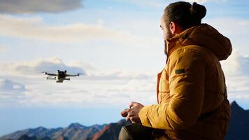 Male influencer shares hiking journey through vlog with drone, recording high quality aerial view content with remote control. Young hiker filming the scenery. Camera B. photo