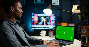 Teleworker editing documents next to mockup on laptop, submitting reports and files before deadline. Black freelancer managing digital paperwork within work platform. Camera A. photo