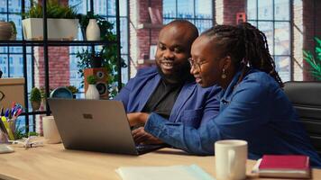 Couple doing teamwork and multitasking on laptop at desk, fully connected to internet while managing freelance work and remote responsibilities. Browsing web at home. Camera A. photo