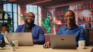Man and woman sit at stylish home office, brainstorming ideas for digital business, using modern technology to improve communication and project efficiency. Camera A. photo