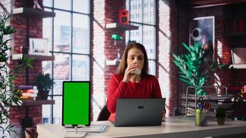 Person using laptop for creative projects next to isolated copy space, creating designs and staying connected to freelance platform. Woman focusing on research and multitasking. Camera B. photo