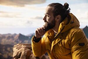 Hiker gazing at panoramic view of mountain peaks and clouds, feeling thrill of adventure and rewards of perseverance. The journey represents strength and personal growth. photo