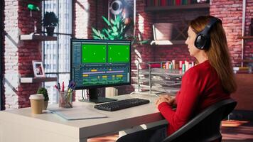 Female creator working on editing movie with green screen, using movie post production software. Female footage editor starting cinematic film editing industry. Camera B. photo