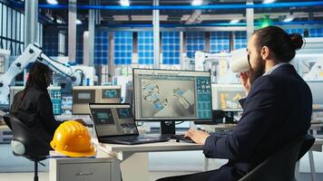 Photovoltaics factory worker monitors system performance, drinking coffee. Solar panels plant employee enjoys beverage while using PC to track energy production and efficiency, camera A photo