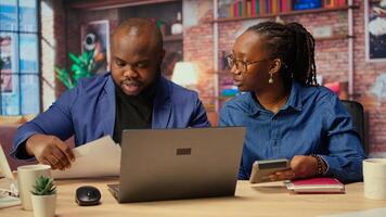 Man and woman review earnings and revenue reports in apartment, using calculator and laptop to ensure accurate accounting and financial planning for tax season. Camera A. photo