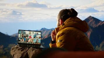 Entrepreneur uses high speed network connection on mountain, enjoying call with scenic landscape. Young hiker having internet dependency and being workaholic. Camera B. photo