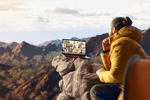 Business employee uses high speed connection on mountain, enjoying call with scenic landscape. Male hiker with internet dependency being workaholic. photo