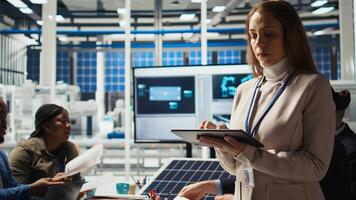 Researcher analyzing solar cell prototypes using tablet to optimize energy production. Cheerful solar panels expert develops innovative manufacturing tech using device, camera A photo