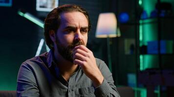 Perplexed supporter watching sports match on TV, surprised by team performance. Man looking at football competition, baffled by easy chance missed by player, camera A closeup photo