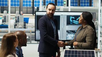 Managers in photovoltaics factory reviewing solar technology reports. Shareholders reading and discussing future investment opportunities in green energy production, camera B photo