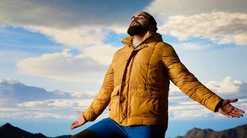 Proud explorer basks in joy of accomplishment standing at mountain peak with arms lifted, mindfulness. Traveler admiring stunning scenic view and vast sky for thrill of hiking. Camera B. photo