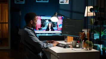 African american expert at desk using pc for programming and data analysis. Young networking expert working from home, manages information technology and data center. Camera B. photo