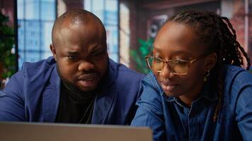 Black man and woman creating report with online data from archived files, improving skills and achieving career independence. Remote workers solving daily tasks. Camera A. photo