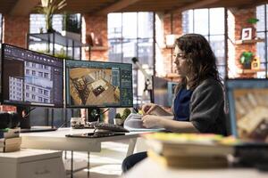 Freelancer designer decorates an apartment floor plan on a computer, using architectural software to configure elements. Woman uses interface to enable rendering and 3D modeling. photo