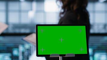 Close up of chroma key tablet next to data scientists conducting security audits, preventing bugs. Green screen device and man working with colleague in data center, camera A photo