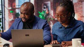 Couple discussing mortgage and insurance payments at home, using calculator to do household budgeting and money management. Ensuring secure financial future. Camera B. photo