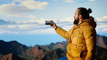 Hiker capturing breathtaking scenic view at top of mountain, gazing at distantand embracing beauty of wilderness. Joy of discovering wonders. Camera B. photo