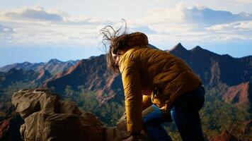 Clumsy hiker tripping and falling off of mountain peak, leading to accident due to lack of attention. Inconsiderate unprepared traveler stumbles on unstable terrain. Camera B. photo