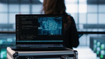 Laptop in front of data center engineers deploying artificial intelligence tools. AI coding on notebook screen next to technicians inspecting server clusters, camera A close up photo