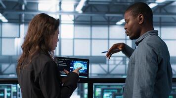 Software developers using AI technology on tablet to optimize storage volumes. IT specialists in server hub facility using artificial intelligence to ensure seamless operations, camera A photo