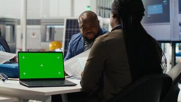 Researchers analyze solar cell prototypes using green screen laptop to optimize energy production. Solar panels experts developing innovative manufacturing tech using mockup notebook photo