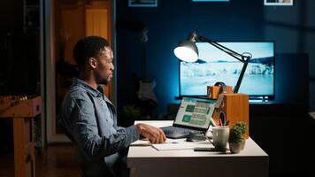 africano americano teletrabajador gerente diario calendario y lo hace memorándum notas, creando recordatorios a garantizar tarea terminación desde hogar oficina. persona de libre dedicación mejorando productividad. cámara b. foto