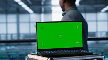 Green screen laptop in front of data center engineers calibrating energy usage, inspecting servers configuration, supporting sustainable infrastructure, camera A photo