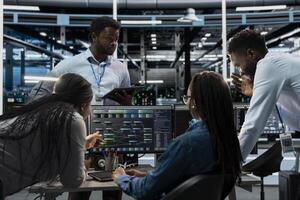 System administrators programming in AI data center housing advanced equipment used for machine learning training. Server hub employees run code on PC to upgrade artificial intelligence systems photo