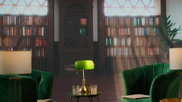 Cozy vintage library with green chairs and whiskey glasses create a classy setting, surrounded by wood bookshelves and warm light. Atmosphere of heritage, tradition and aristocracy. photo