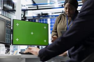 Solar tech workforce reviews diagnostics on pc next to mockup, supporting clean smart energy production and manufacturing process evolution. Working on sustainable solutions at the plant. photo
