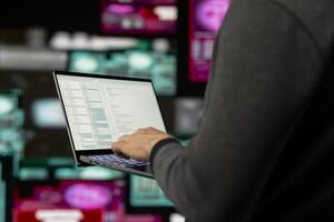 Cyber crime unfolds as a spy is targeting network systems with code, bypassing encryption and engaging in exploit. Man practices identity theft and data breaches through AI manipulation. photo