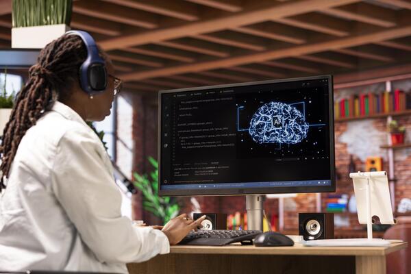Freelancing computer engineer doing maintenance on artificial intelligence systems, listening music. Remote tech support specialist working from home wearing headphones, doing checkup on AI systems