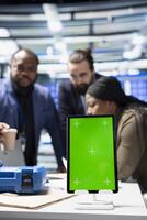 Solar panel inspection group review data on pc next to green screen, finding errors during a process audit and helping optimize renewable energy operations. Photovoltaics factory. photo