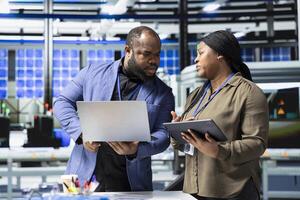 African American engineers industrial coworkers doing teamwork on production line for solar panels, combining technical insight and teamwork to drive forward clean energy infrastructure. photo