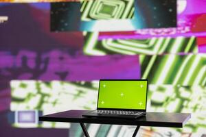 Wireless pc running chroma key display surrounded by colorful visual art clips, glowing in the dark and showcasing a clubbing atmosphere. Nightlife ambiance with urban lights and vibes. photo