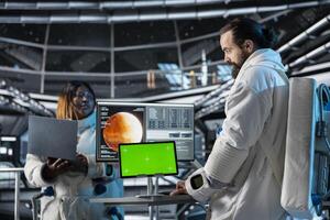 Space station researchers analyzing Mars planetary data using isolated screen tablet. Team of scientists in futuristic spaceship doing Martian surface research using mockup device photo