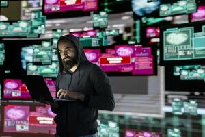 Male hacker operates in stealth mode breaching system access through coding, bypassing firewalls and exploiting vulnerabilities in network security to carry out cyber crime and data infiltration. photo