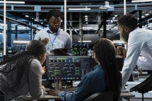 Data center system administrators using PC to visualize artificial intelligence neural networks made up of interconnected nodes. Server farm coworkers doing brainstorming, overseeing AI systems photo