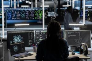 Data center software developer uses AI visualization tool to oversee automated repetitive tasks. Server room worker adapting infrastructure systems based on data analytics graphs using PC photo