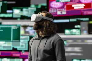 Hacker uses virtual reality glasses for system infiltration and penetration, cyber intelligence define this tech driven information theft. Intrusion and threat alerts reveal dangerous hacking. photo