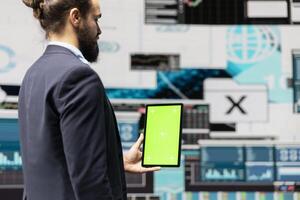 Male administrator using chroma key display for a digital analysis, ensures financial planning and business success with digital growth driven tools and monthly reports. Insightfulness. photo
