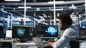 Data center computer scientist in wheelchair using AI node tree software to minimize system downtime. Server hub employee in disability using artificial intelligence visual programming tool, camera A photo