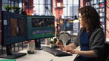 Female videographer working with dual monitors at the creative agency, editing montage and does color grading for the creative process. Post production to create footage. Camera A. photo