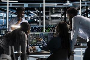 Data center programmers doing brainstorming, setting up machine learning systems handling information. Teamworking colleagues training neural networks to improve server farm operations photo