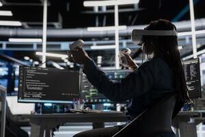 Data center admin using virtual reality to setup machine learning systems handling information. IT specialist using VR headset to train neural networks to improve server farm operations photo