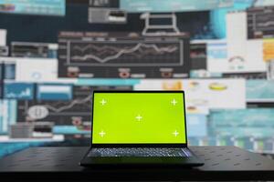 Laptop with a copy space display on empty desk next to performance metrics, showcasing finance graphs and strategy tools to guide a new investment and decision making. Business growth. photo