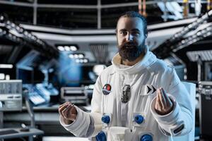 Astronaut does explanation in starship during videocall with command center on Earth. Orbit station crew member talks with researchers, doing mission update during communication link to ground control photo